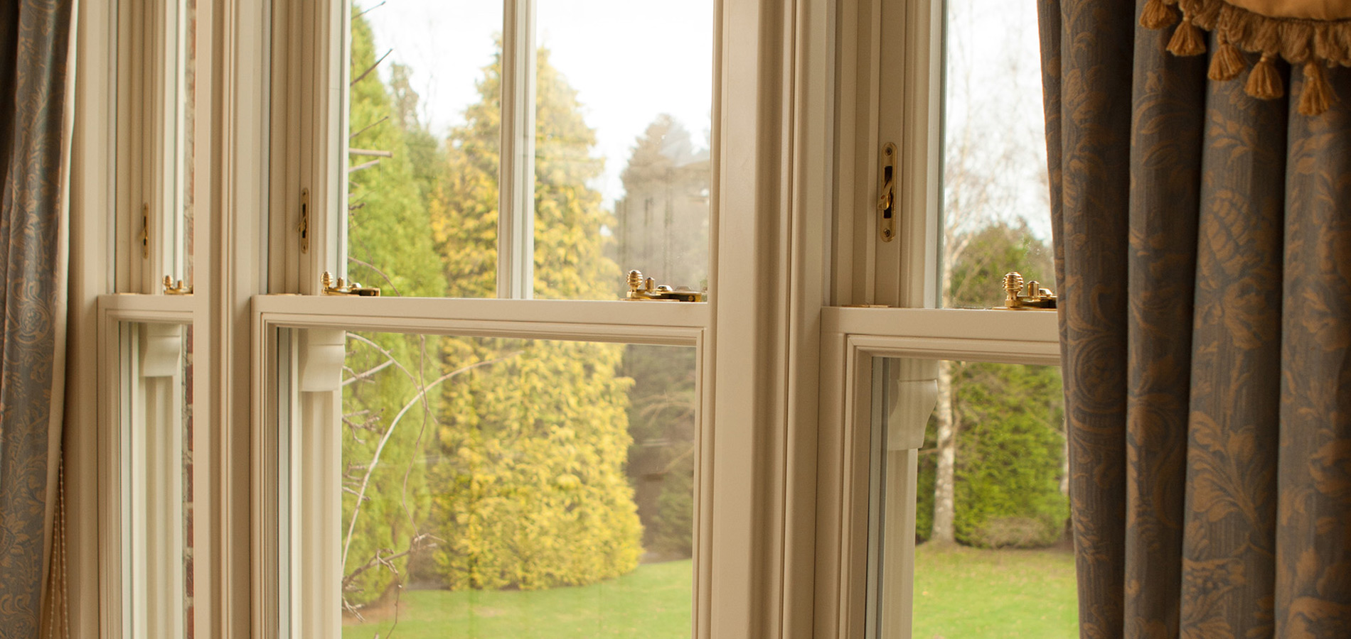 Internal image of traditional timber vertical sliding windows with brass hardware